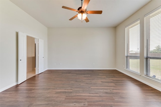 unfurnished room with plenty of natural light, a ceiling fan, baseboards, and wood finished floors