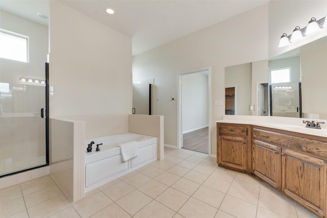 full bathroom with a stall shower, a garden tub, vanity, and a healthy amount of sunlight