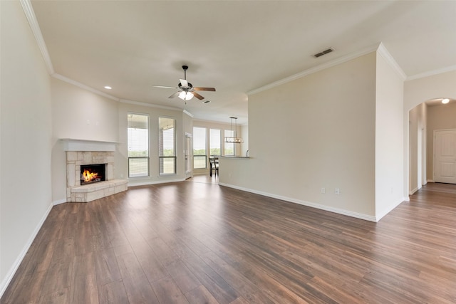 unfurnished living room with visible vents, dark wood-type flooring, arched walkways, baseboards, and ceiling fan
