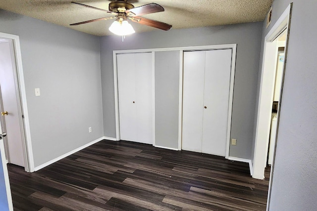 unfurnished bedroom featuring a textured ceiling, dark wood finished floors, a ceiling fan, baseboards, and a closet