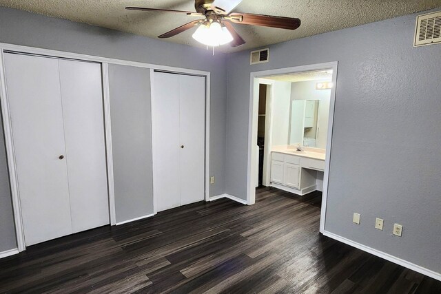 unfurnished bedroom with visible vents, baseboards, and dark wood-type flooring