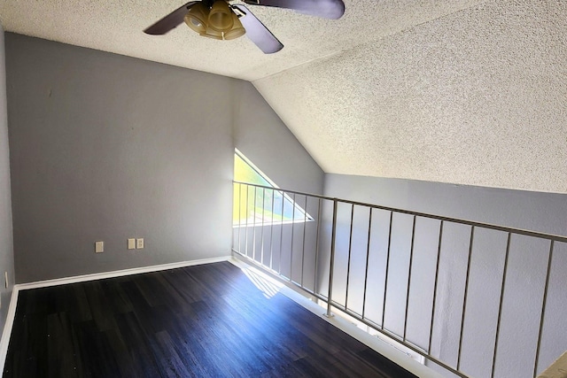 bonus room featuring ceiling fan, a textured ceiling, vaulted ceiling, wood finished floors, and baseboards