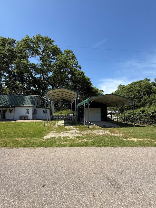111 County Road 2156, Quitman, TX 75783 - view of front of property featuring a detached carport, driveway, an outbuilding, and a front yard