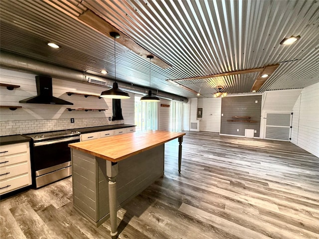 111 County Road 2156, Quitman, TX 75783 - kitchen featuring open shelves, wood finished floors, butcher block counters, wall chimney exhaust hood, and stainless steel electric range oven