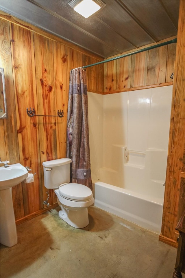 14615 County Road 2337, Tyler, TX 75707 - bathroom featuring wood walls, toilet, a sink, concrete flooring, and shower / bath combo