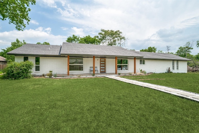 ranch-style home featuring brick siding and a front lawn