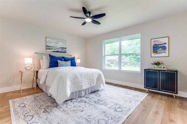 bedroom featuring wood finished floors, baseboards, and ceiling fan