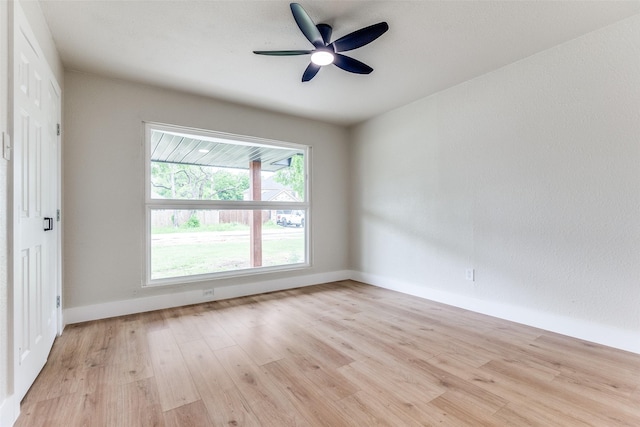 spare room with baseboards, a ceiling fan, and light wood-style flooring