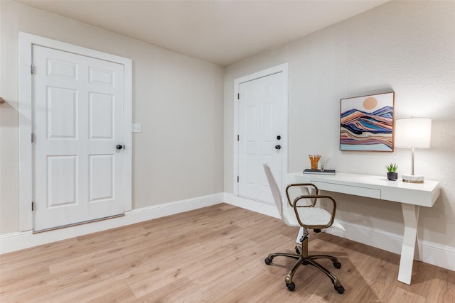 home office with baseboards and light wood-style flooring