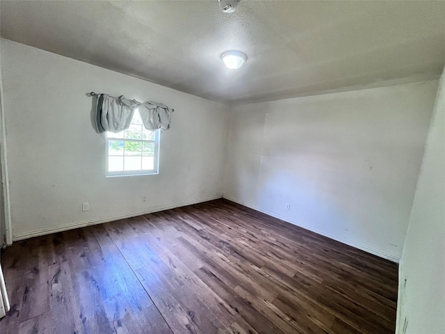 715 Elm St, Mckinney, TX 75069 - spare room with dark wood-type flooring, baseboards, and a textured ceiling