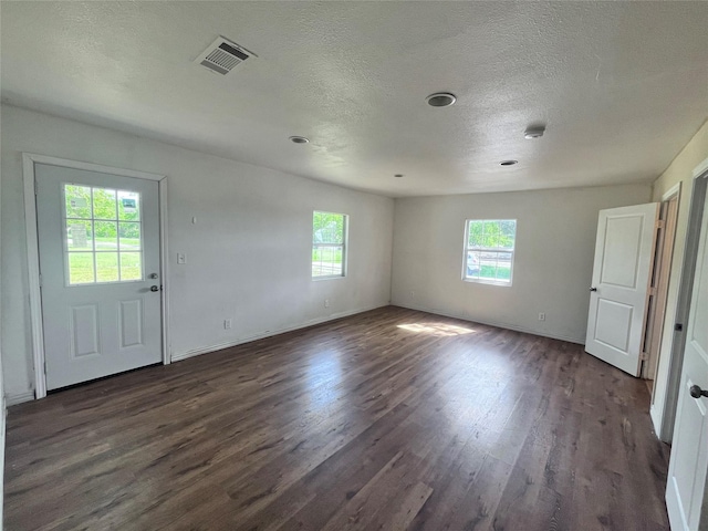 715 Elm St, Mckinney, TX 75069 - unfurnished room featuring healthy amount of natural light, dark wood-type flooring, a textured ceiling, and baseboards