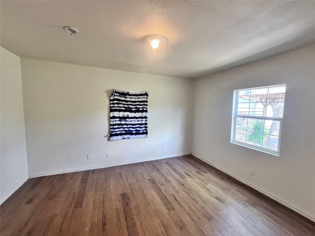 715 Elm St, Mckinney, TX 75069 - spare room featuring wood finished floors, baseboards, and a textured ceiling