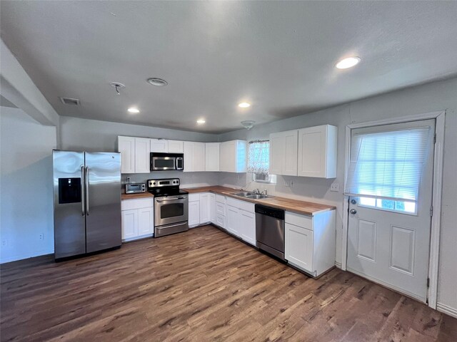 715 Elm St, Mckinney, TX 75069 - kitchen with stainless steel appliances, plenty of natural light, dark wood-type flooring, white cabinetry, and recessed lighting