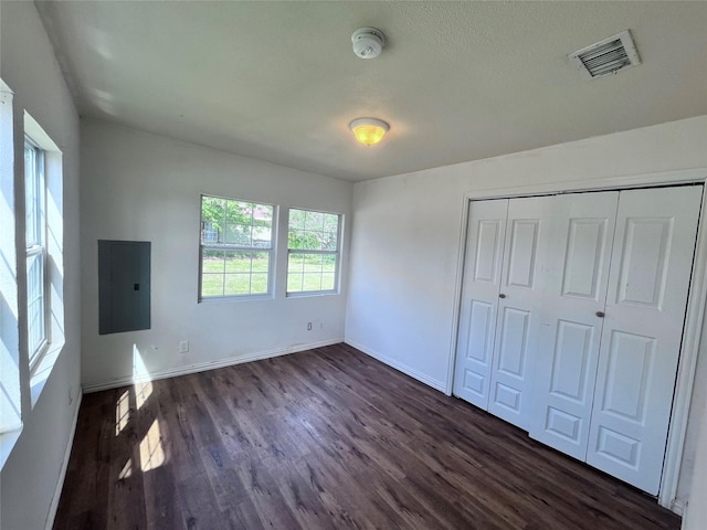 715 Elm St, Mckinney, TX 75069 - unfurnished bedroom featuring electric panel, dark wood finished floors, baseboards, and a closet