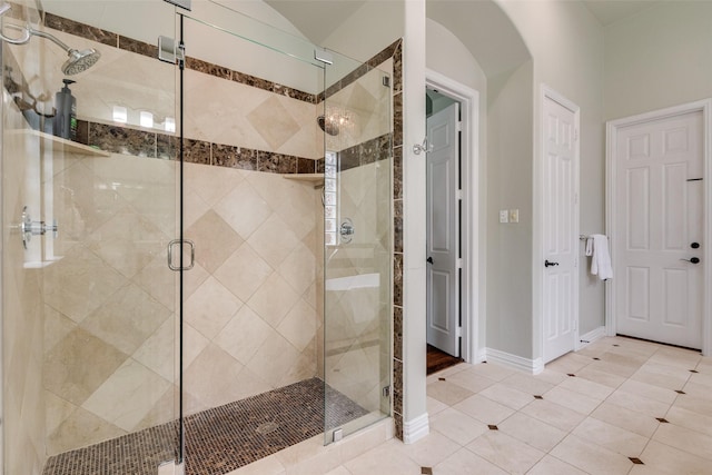 bathroom featuring baseboards, tile patterned flooring, and a shower stall