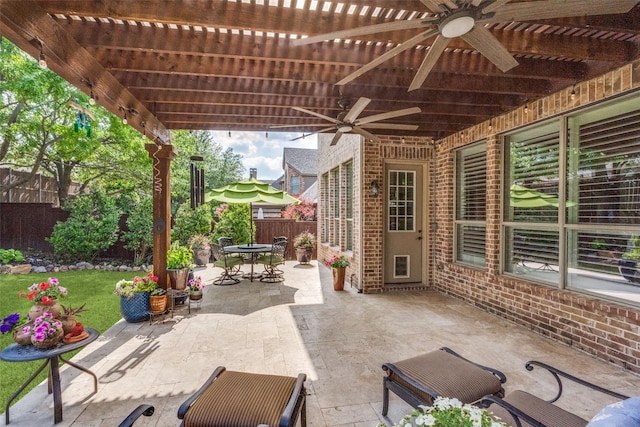 view of patio featuring a pergola, a ceiling fan, outdoor dining space, and a fenced backyard