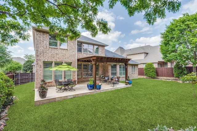 back of property with a lawn, a fenced backyard, brick siding, and a patio