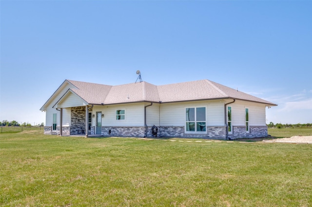 exterior space featuring a shingled roof and a front lawn