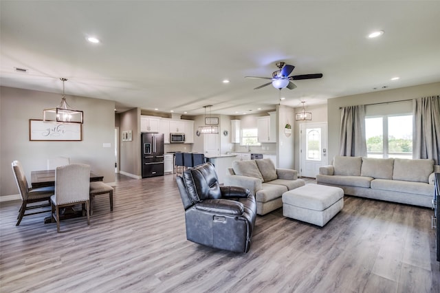 living area with recessed lighting, baseboards, and ceiling fan