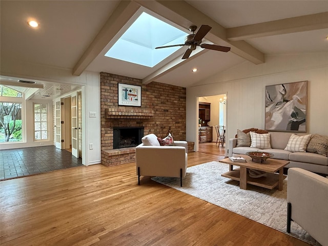 11147 Carissa Dr, Dallas, TX 75218 - living room featuring recessed lighting, wood finished floors, a ceiling fan, lofted ceiling with skylight, and a fireplace