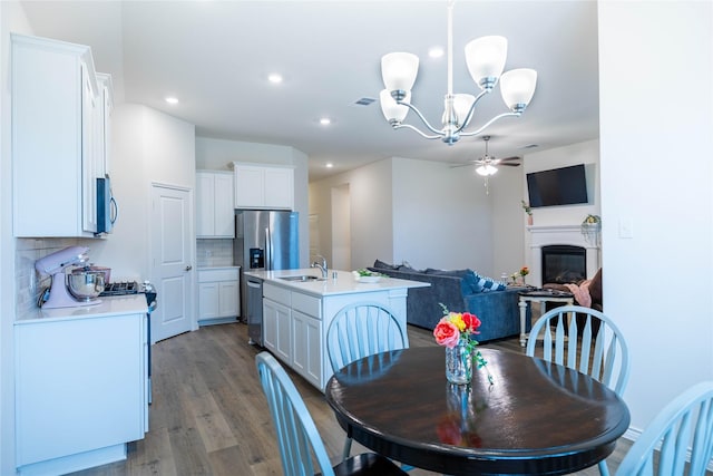 2712 Cain Dr, Anna, TX 75409 - dining room featuring ceiling fan with notable chandelier, a glass covered fireplace, visible vents, dark wood-style floors, and recessed lighting