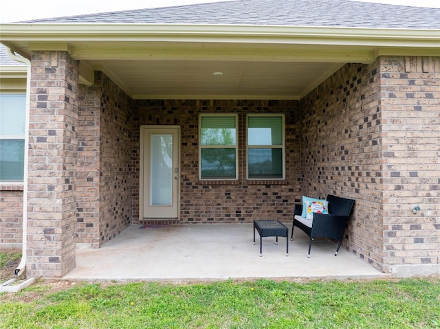 2712 Cain Dr, Anna, TX 75409 - view of exterior entry featuring brick siding, a patio area, and a shingled roof