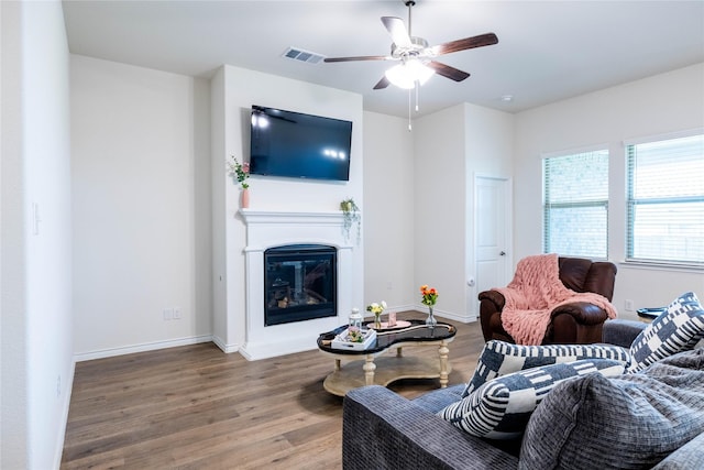 2712 Cain Dr, Anna, TX 75409 - living area featuring baseboards, a glass covered fireplace, visible vents, a ceiling fan, and wood finished floors