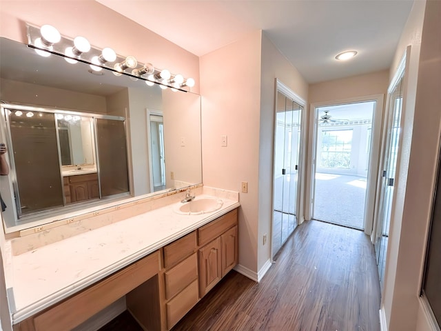 full bathroom with baseboards, vanity, and wood finished floors