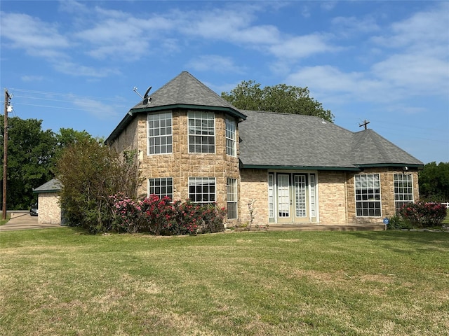 view of front of house with a shingled roof, a front lawn, and french doors