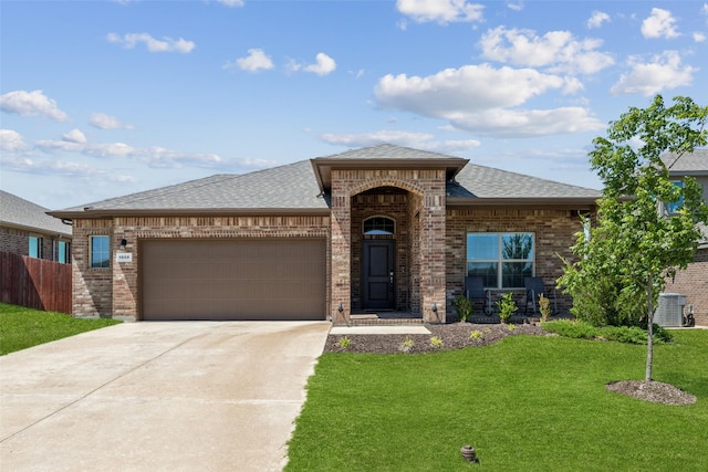 view of front of property with roof with shingles, an attached garage, driveway, brick siding, and a front yard