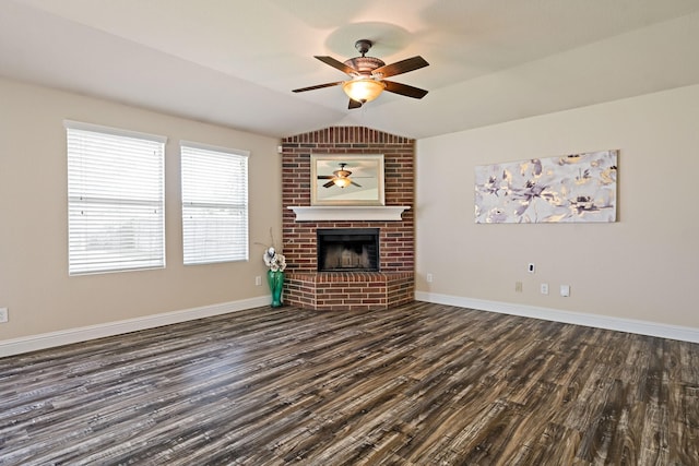 unfurnished living room with dark wood-style flooring, vaulted ceiling, baseboards, ceiling fan, and a fireplace