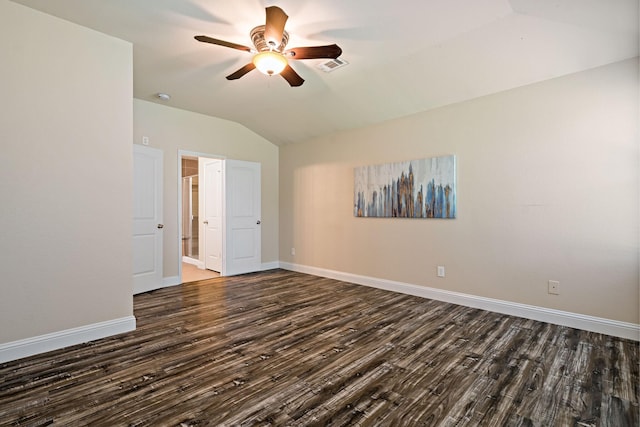 empty room featuring dark wood finished floors, vaulted ceiling, visible vents, baseboards, and ceiling fan
