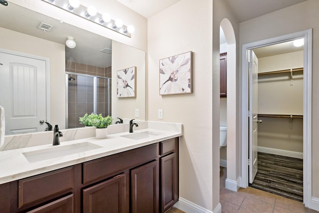 full bath featuring a shower stall, visible vents, tile patterned flooring, and a sink