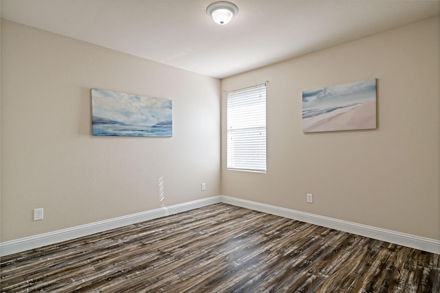 empty room with baseboards and dark wood finished floors