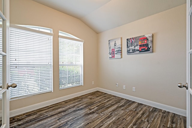 unfurnished room with vaulted ceiling, baseboards, and dark wood-style flooring