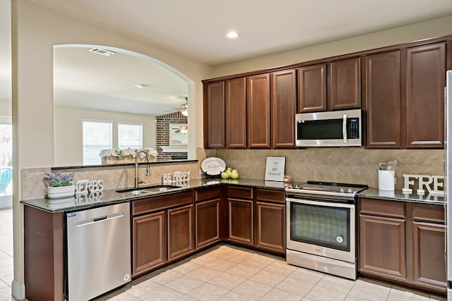 kitchen with visible vents, appliances with stainless steel finishes, dark stone countertops, and a sink