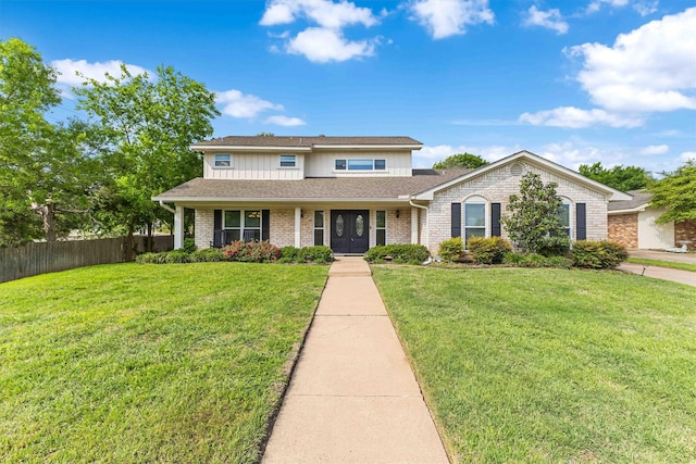 traditional-style home with brick siding, a shingled roof, a front yard, and fence