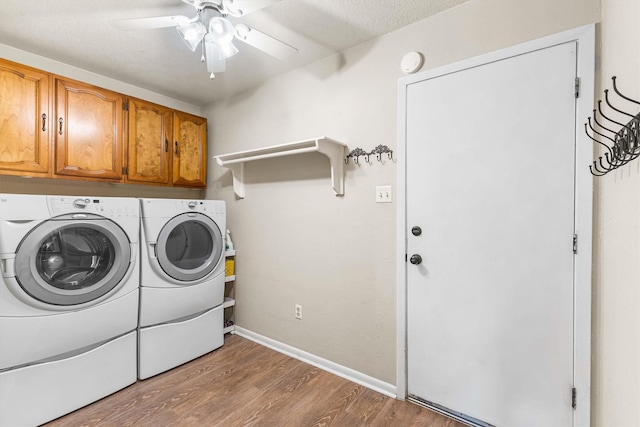 washroom featuring baseboards, separate washer and dryer, wood finished floors, ceiling fan, and cabinet space