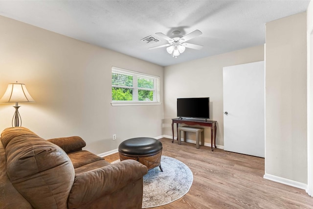 living room with ceiling fan, baseboards, wood finished floors, and visible vents