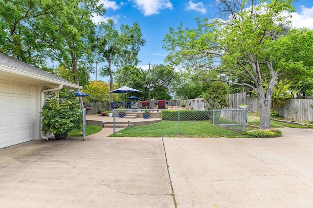 view of patio with fence private yard and a garage