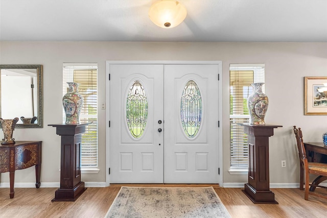 foyer with baseboards and light wood finished floors