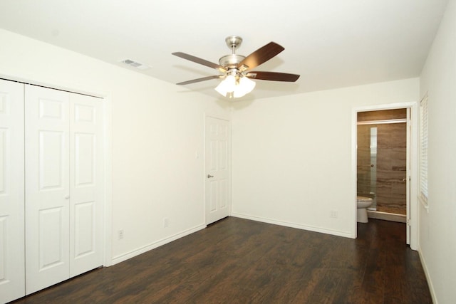unfurnished bedroom with wood finished floors, visible vents, ensuite bath, a closet, and baseboards