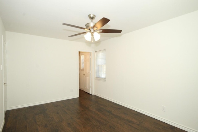 spare room with ceiling fan, baseboards, and dark wood-style floors