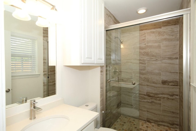 full bath featuring toilet, vanity, recessed lighting, and a stall shower
