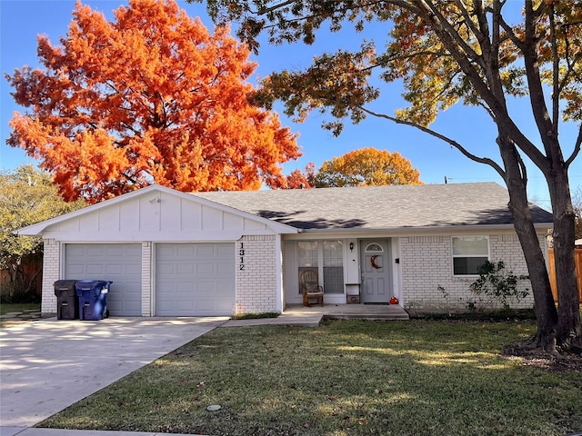ranch-style house featuring a front lawn, driveway, brick siding, an attached garage, and board and batten siding