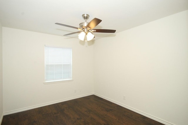 spare room with baseboards, dark wood-type flooring, and ceiling fan
