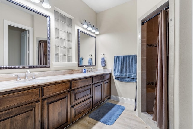 7305 Caladium Dr, Mckinney, TX 75070 - full bathroom with double vanity, tiled shower, and wood finished floors