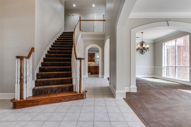 1809 Cotton Mill Dr, Mckinney, TX 75072 - foyer entrance featuring arched walkways, an inviting chandelier, stairway, crown molding, and light tile patterned floors