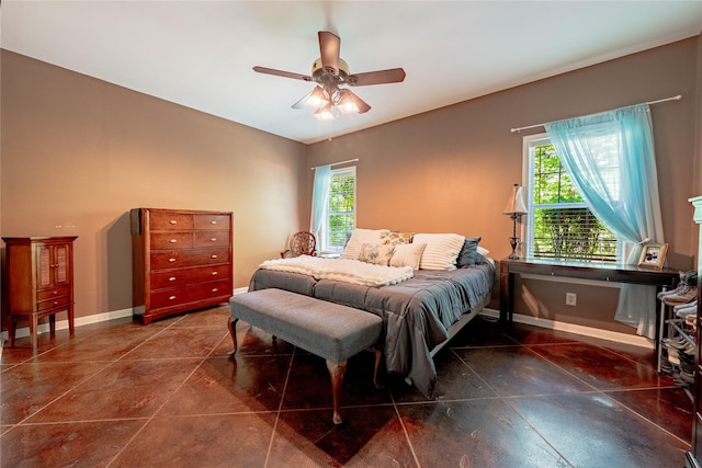 bedroom featuring baseboards, a ceiling fan, and multiple windows