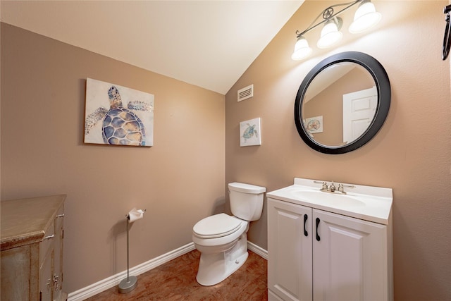 half bath with toilet, vaulted ceiling, baseboards, visible vents, and vanity
